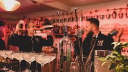 Zwei Barkeeper mixen hinter der Bar Cocktails