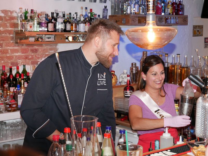 Exclusiver Kurs bei dem Junggesellenabschied, 2 Personen stehen mit einem Shaker hinter der Bar