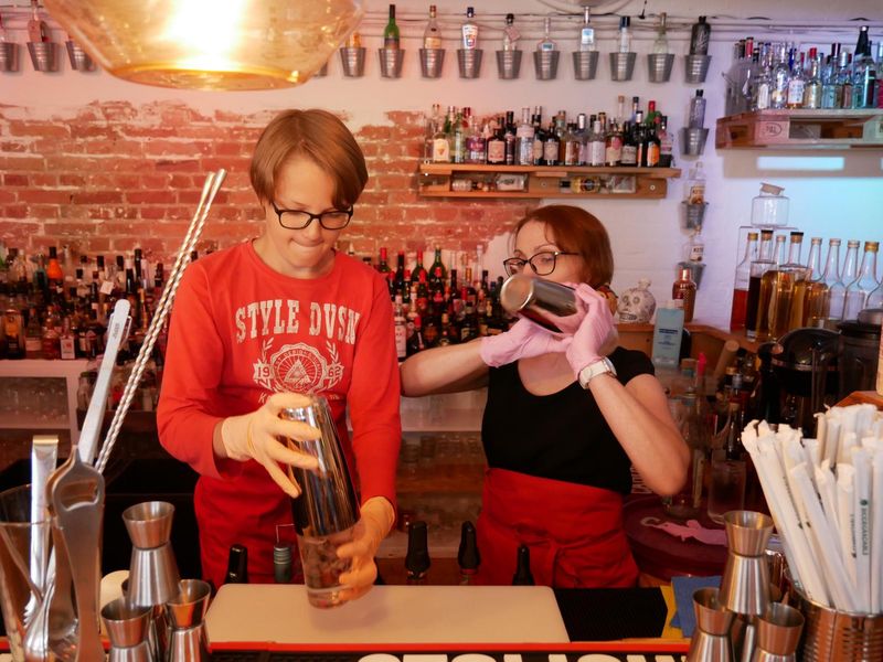 Teilnehmer bei dem Kindergeburtstags-Cocktailworkshop mixen hinter der Bar Cocktails