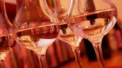 Mehrere Gin-Flaschen stehen aufgereiht auf einer Bar