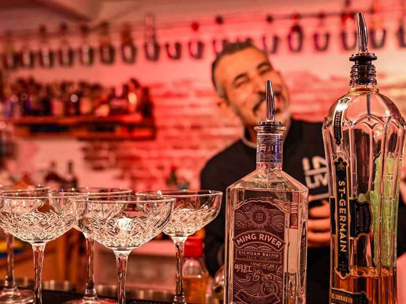Bilder mit Gin-Flasche und Gläsern auf der Bar im Profi-Cocktail-Workshop