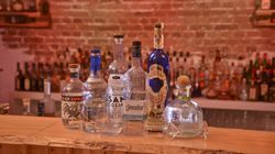 Mehrere Tequila-Flaschen stehen aufgereiht auf einer Bar