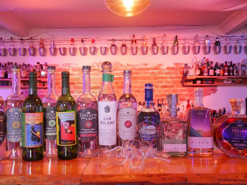 Mehrere Tequila-Flaschen stehen aufgereiht auf einer Bar